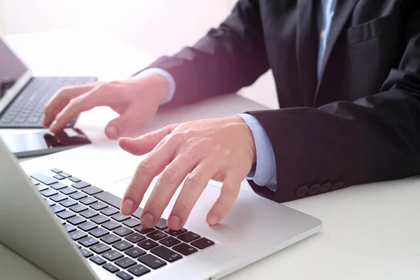 Mains d'homme d'affaires tapant sur ordinateur portable dans un bureau moderne avec smar — Photo
