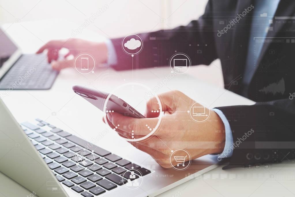 Hands of businessman using mobile phone in modern office with la