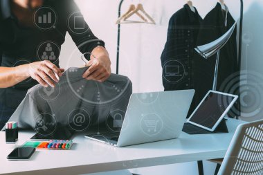 Moda gömlek tutarak ve dizüstü bilgisayar ile dijital sekmesini kullanarak Tasarımcısı