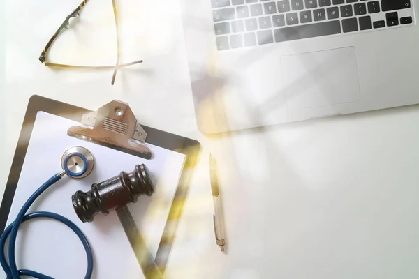 Ciemny młotek z medyczny stetoskop w pobliżu Laptop na biały biurko w — Zdjęcie stockowe