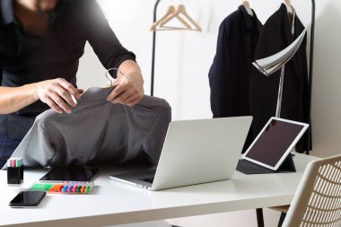 Moda gömlek tutarak ve dizüstü bilgisayar ile dijital sekmesini kullanarak Tasarımcısı