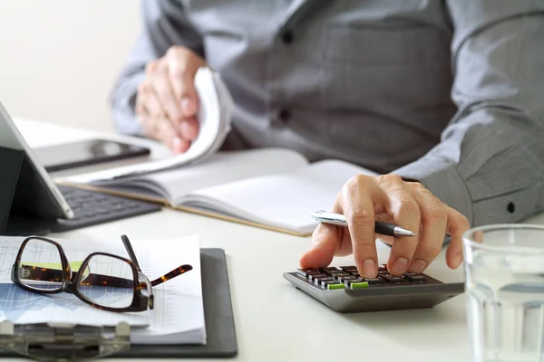 Affärsman hand arbetar med finanser om kostnads- och kalkylator — Stockfoto