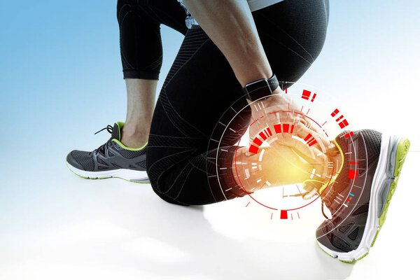 Athletic man touching foot due to sprain with VR medical scannin