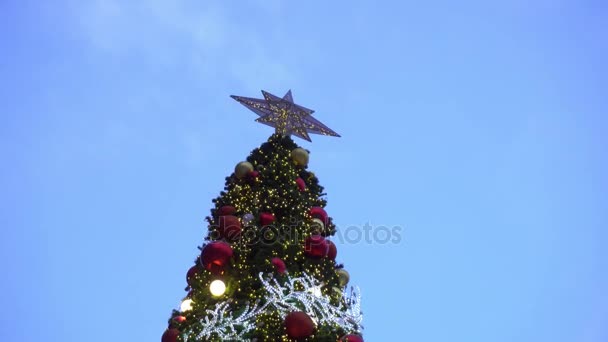 Pozdravem sezóny koncept. Gimbal záběr ozdoby na velký vánoční stromek s dekorativní světlo a padající sníh v rozlišení 4k (Uhd)