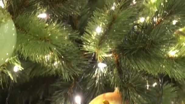 Saison de salutation concept.Gimbal tir d'ornements sur un grand arbre de Noël avec la lumière décorative et la neige tombante en 4k (UHD )