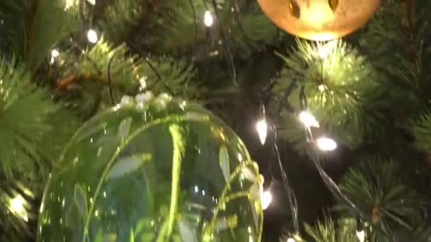 Saison de salutation concept.Gimbal tir d'ornements sur un grand arbre de Noël avec la lumière décorative et la neige tombante en 4k (UHD )