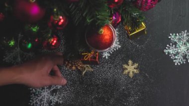 Tebrik sezon kavramı. El ayarı Noel ağacı ve süslemeleri ile sunar ve masada beyaz tahta yukarıdan yağan kar 4 k (Uhd süsler)