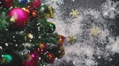 Tebrik sezon kavramı. Noel ağacı ve süslemeleri ile el ayarı sunar ve masada beyaz tahta yukarıdan yağan kar 4 k (Uhd süsler)
