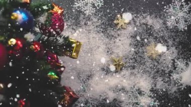 Tebrik sezon kavramı. Noel ağacı ve süslemeleri ile el ayarı sunar ve masada beyaz tahta yukarıdan yağan kar 4 k (Uhd süsler)