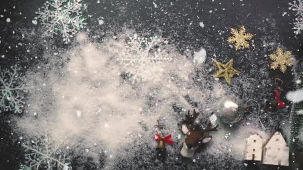 Pozdravem sezóny koncept. Ruční nastavení vánoční stromek a ozdoby s dárky a ozdoby na bílé dřevo stůl z výšky s padajícím sněhem v rozlišení 4k (Uhd)