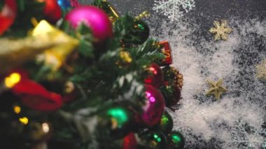Tebrik sezon kavramı. Noel ağacı ve süslemeleri ile el ayarı sunar ve masada beyaz tahta yukarıdan yağan kar 4 k (Uhd süsler)