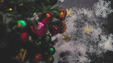 Tebrik sezon kavramı. Noel ağacı ve süslemeleri ile el ayarı sunar ve masada beyaz tahta yukarıdan yağan kar 4 k (Uhd süsler)