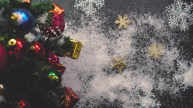 Tebrik sezon kavramı. Noel ağacı ve süslemeleri ile el ayarı sunar ve masada beyaz tahta yukarıdan yağan kar 4 k (Uhd süsler)