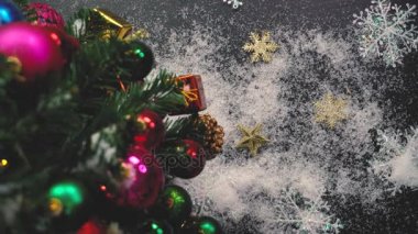 Tebrik sezon kavramı. Noel ağacı ve süslemeleri ile el ayarı sunar ve masada beyaz tahta yukarıdan yağan kar 4 k (Uhd süsler)