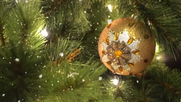 Salutations Concept de saison. Prise de vue à la carabine d'ornements sur un grand sapin de Noël avec lumière décorative et neige tombante en 4k (UHD )