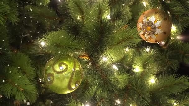 Salutations Concept de saison. Prise de vue à la carabine d'ornements sur un grand sapin de Noël avec lumière décorative et neige tombante en 4k (UHD )