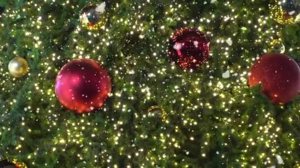 Pozdravem sezóny koncept. Gimbal záběr ozdoby na velký vánoční stromek s dekorativní světlo a padající sníh v rozlišení 4k (Uhd)