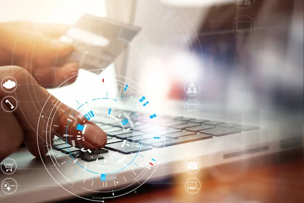 Close-up de mão usando cartão de crédito e computador portátil em madeira — Fotografia de Stock