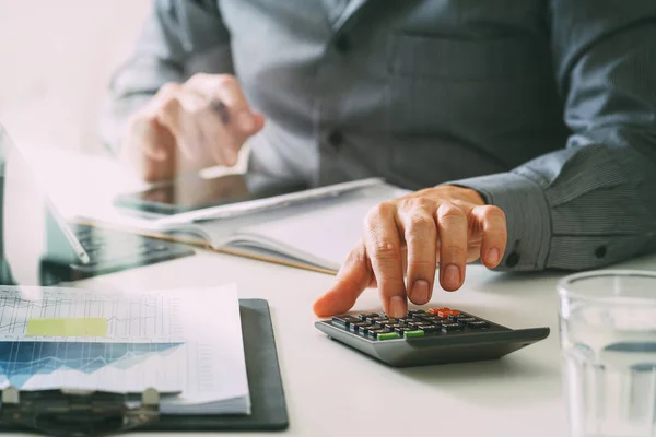 Geschäftsmann Hand arbeitet mit Finanzen über Kosten und Taschenrechner — Stockfoto