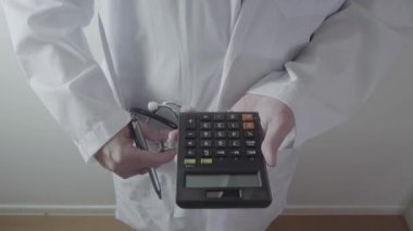 Sağlık masrafları ve ücretleri kavramı. Akıllı doktor el modern hastanede tıbbi masrafları için bir hesap makinesi kullanılır