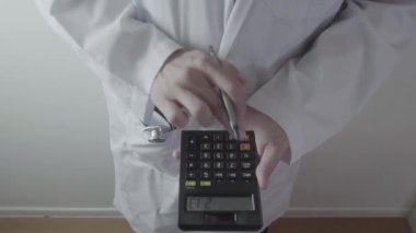 Sağlık masrafları ve ücretleri kavramı. Akıllı doktor el modern hastanede tıbbi masrafları için bir hesap makinesi kullanılır