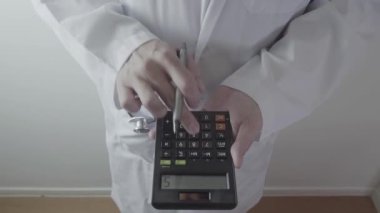 Sağlık masrafları ve ücretleri kavramı. Akıllı doktor el modern hastanede tıbbi masrafları için bir hesap makinesi kullanılır