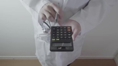 Sağlık masrafları ve ücretleri kavramı. Akıllı doktor el modern hastanede tıbbi masrafları için bir hesap makinesi kullanılır