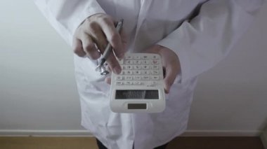 Sağlık masrafları ve ücretleri kavramı. Akıllı doktor el modern hastanede tıbbi masrafları için bir hesap makinesi kullanılır