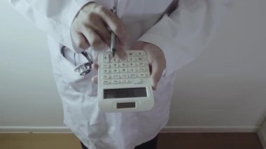 Sağlık masrafları ve ücretleri kavramı. Akıllı doktor el modern hastanede tıbbi masrafları için bir hesap makinesi kullanılır