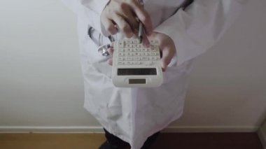 Sağlık masrafları ve ücretleri kavramı. Akıllı doktor el modern hastanede tıbbi masrafları için bir hesap makinesi kullanılır