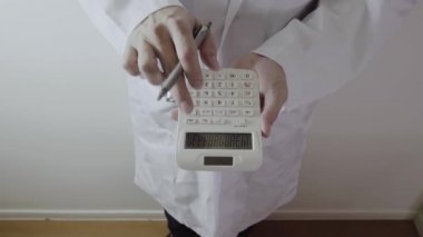 Sağlık masrafları ve ücretleri kavramı. Akıllı doktor el modern hastanede tıbbi masrafları için bir hesap makinesi kullanılır