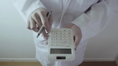 Sağlık masrafları ve ücretleri kavramı. Akıllı doktor el modern hastanede tıbbi masrafları için bir hesap makinesi kullanılır