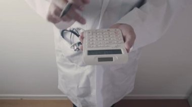 Sağlık masrafları ve ücretleri kavramı. Akıllı doktor el modern hastanede tıbbi masrafları için bir hesap makinesi kullanılır