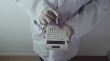 Sağlık masrafları ve ücretleri kavramı. Akıllı doktor el modern hastanede tıbbi masrafları için bir hesap makinesi kullanılır