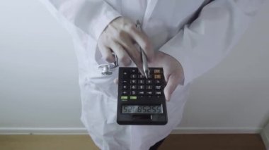 Sağlık masrafları ve ücretleri kavramı. Akıllı doktor el modern hastanede tıbbi masrafları için bir hesap makinesi kullanılır