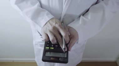 Sağlık masrafları ve ücretleri kavramı. Akıllı doktor el modern hastanede tıbbi masrafları için bir hesap makinesi kullanılır