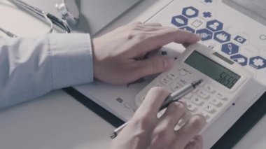 Sağlık görünümünü maliyeti ve kavram ücretleri. Ağır çekimde modern hastanede tıbbi masrafları için bir hesap makinesi akıllı doktor el kullanılır