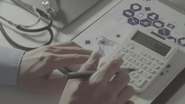 ヘルスケアのビューの上の費用し 料金の概念 スマート ドクターの手がスローモーションで近代的な病院での医療費のため電卓を使用 — ストック動画