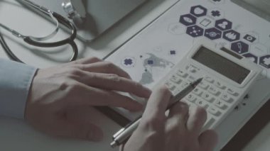 Sağlık görünümünü maliyeti ve kavram ücretleri. Ağır çekimde modern hastanede tıbbi masrafları için bir hesap makinesi akıllı doktor el kullanılır