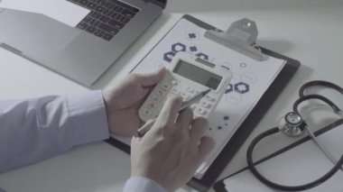 Sağlık görünümünü maliyeti ve kavram ücretleri. Ağır çekimde modern hastanede tıbbi masrafları için bir hesap makinesi akıllı doktor el kullanılır