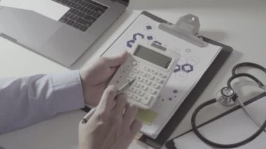 Sağlık görünümünü maliyeti ve kavram ücretleri. Ağır çekimde modern hastanede tıbbi masrafları için bir hesap makinesi akıllı doktor el kullanılır