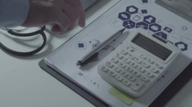 Sağlık görünümünü maliyeti ve kavram ücretleri. Ağır çekimde modern hastanede tıbbi masrafları için bir hesap makinesi akıllı doktor el kullanılır