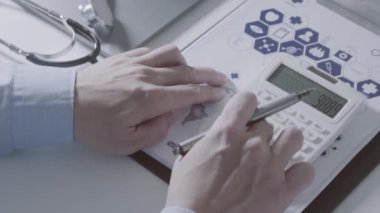 Sağlık görünümünü maliyeti ve kavram ücretleri. Ağır çekimde modern hastanede tıbbi masrafları için bir hesap makinesi akıllı doktor el kullanılır