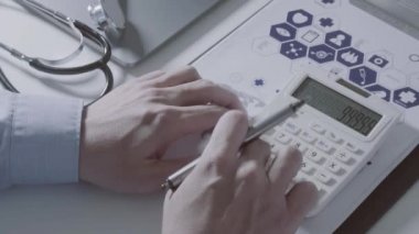 Sağlık görünümünü maliyeti ve kavram ücretleri. Ağır çekimde modern hastanede tıbbi masrafları için bir hesap makinesi akıllı doktor el kullanılır