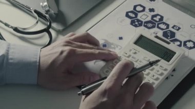 Sağlık görünümünü maliyeti ve kavram ücretleri. Ağır çekimde modern hastanede tıbbi masrafları için bir hesap makinesi akıllı doktor el kullanılır