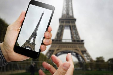 Paris 'teki turist Eyfel Kulesi' ni ziyaret ediyor, Fransa 'yı geziyor, cep telefonuyla fotoğraf çekiyor..
