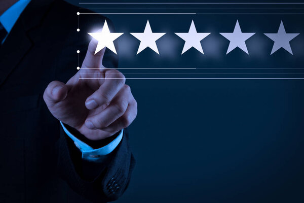 Five stars (5) rating with a businessman is touching virtual computer screen.For positive customer feedback and review with excellent performance.