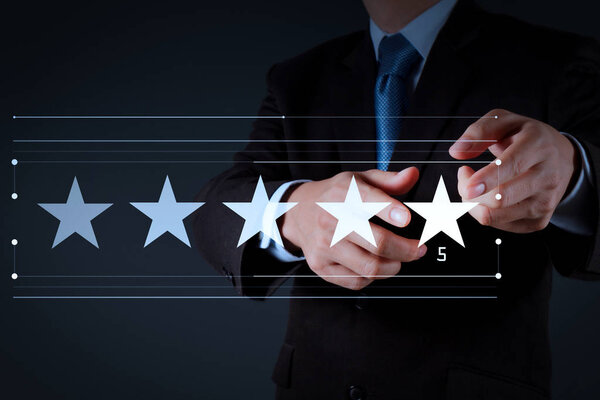 Five stars (5) rating with a businessman is touching virtual computer screen.For positive customer feedback and review with excellent performance.