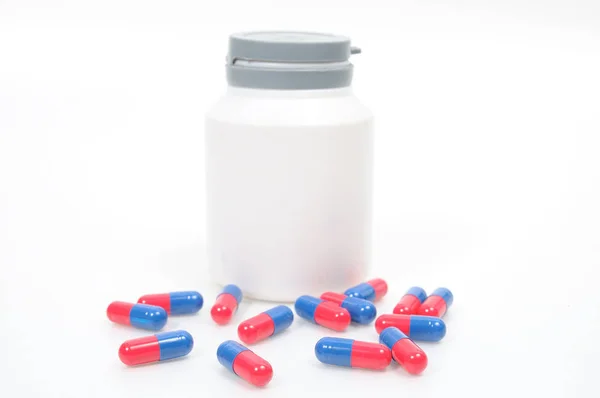 Antibiotics red and blue capsules with bowl drugs — Stock Photo, Image