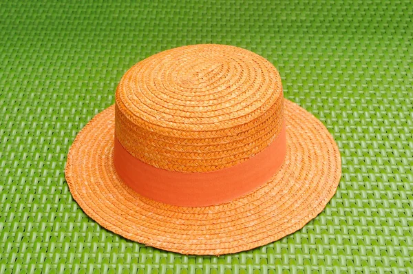 Sombrero naranja en sofá de tejido verde . —  Fotos de Stock